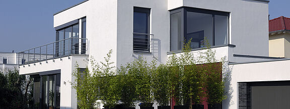 Weißes Einfamilienhaus mit anthrazitfarbenen Fenstern