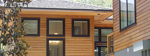 Detached house with wooden panels, window profiles laminated with RENOLIT EXOFOL